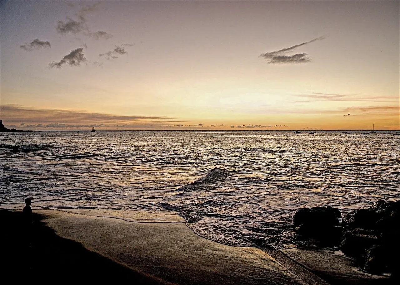 A beach with waves coming in from the ocean.